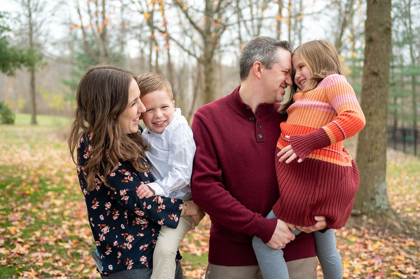 Smiling family holding children during fall mini session