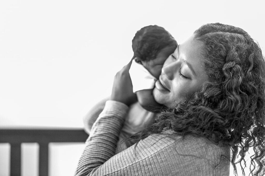 Mother holding her newborn gently against her face