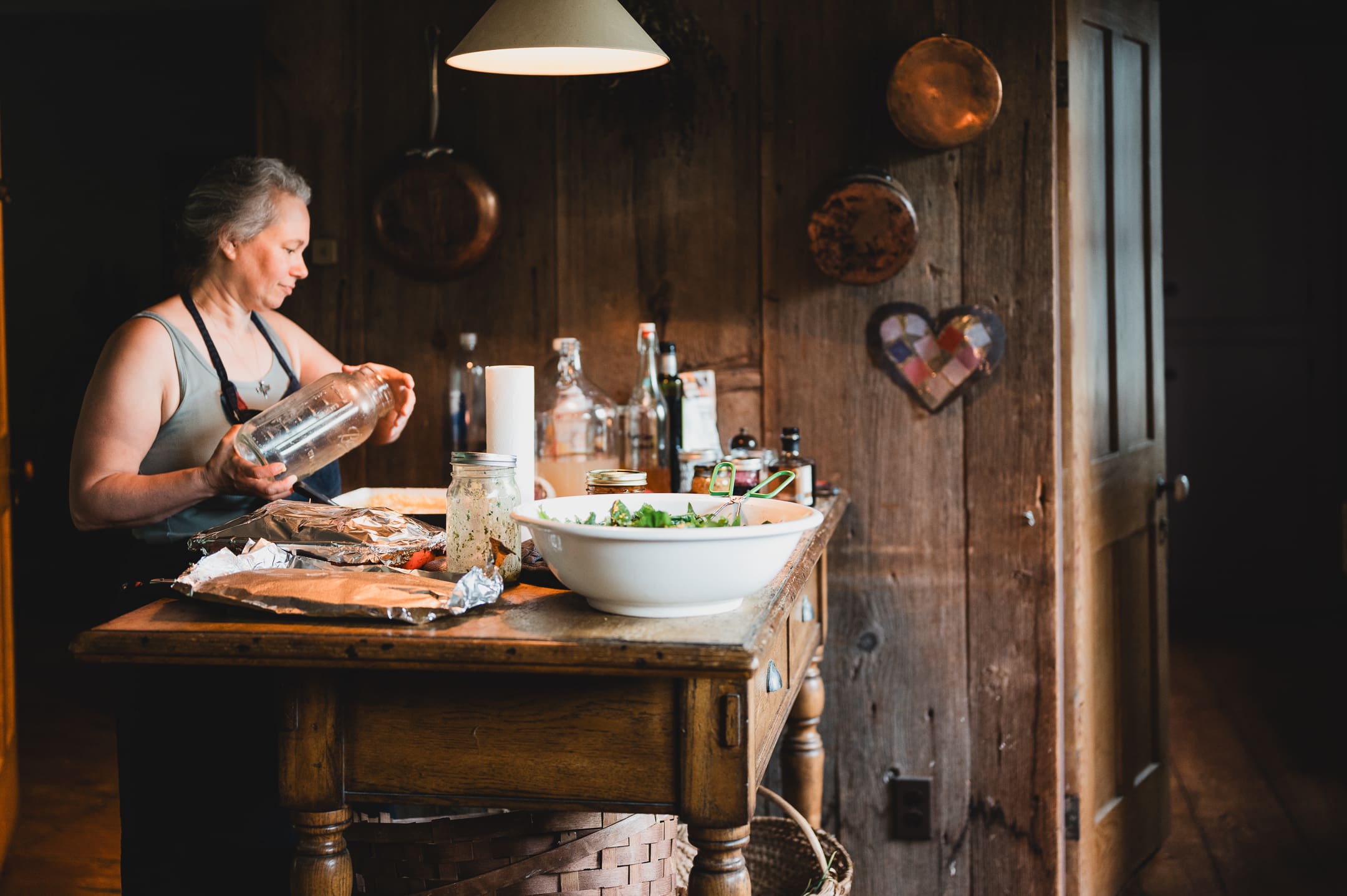 Woman cooking a tray in a warmly lit rustic kitchen