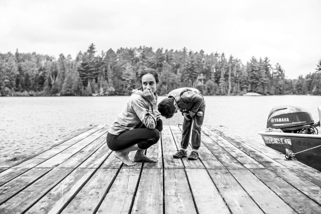 Mother and child on a dock by the lake sharing a quiet moment