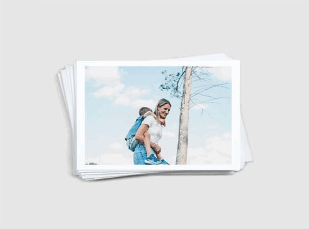 Pile of printed family photos with white borders on professional paper