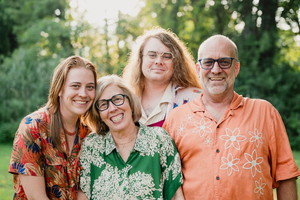 Family of four laughing together during fall family mini session in park
