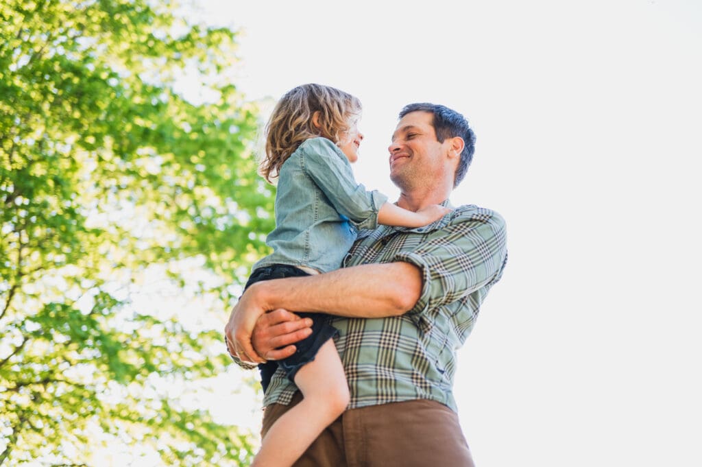 Father holding young child during outdoor fall family photography session
