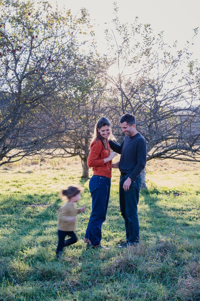 Parents standing together while their child runs past during a relaxed lifestyle family photography session