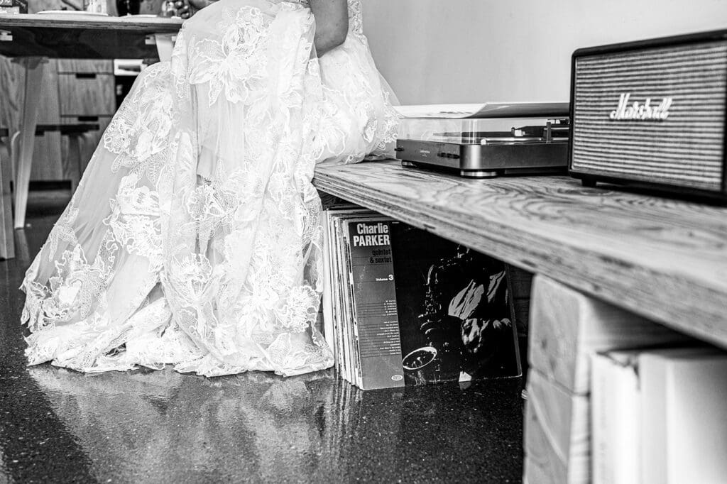 bride sit indoors during at home elopement next to her record player getting ready moments