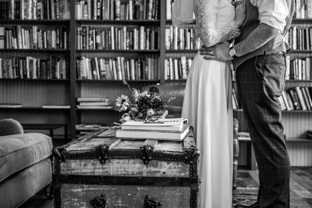 couple standing together indoors during an intimate elopement ceremony with bookshelves in the background