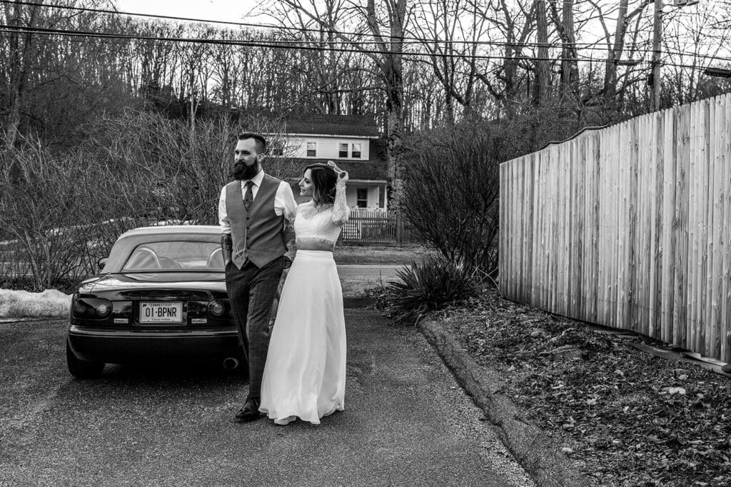 couple standing near a car before their elopement ceremony in a casual outdoor setting