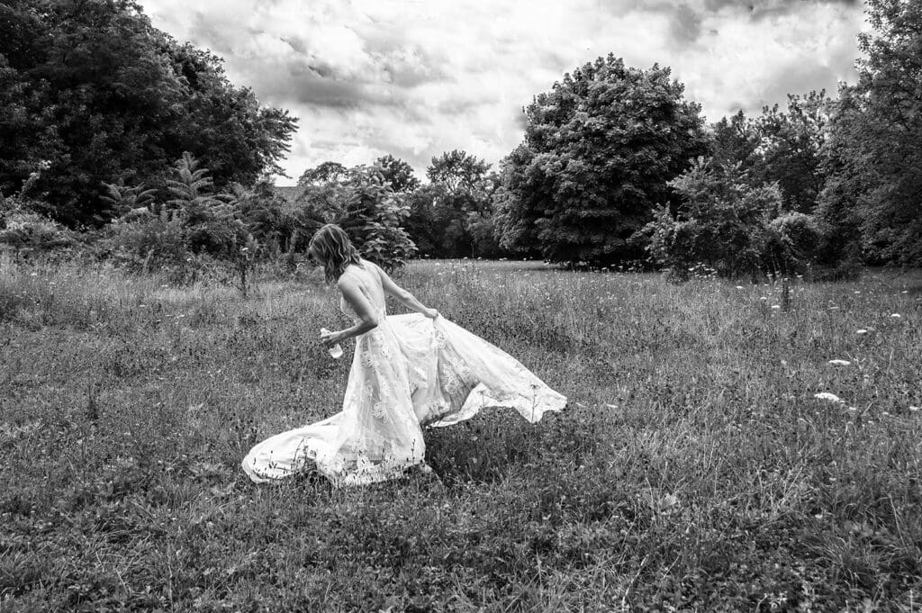 bride spinning in a field during an outdoor elopement session capturing a natural and unscripted moment