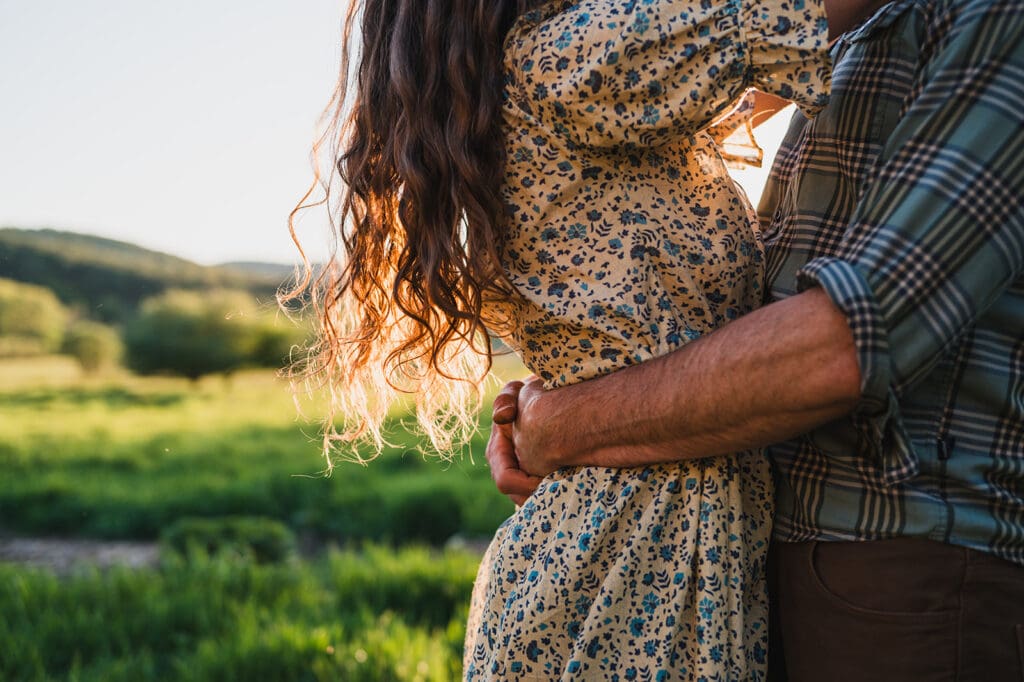 close up of couple embracing outdoors wearing complementary plaid and floral patterns