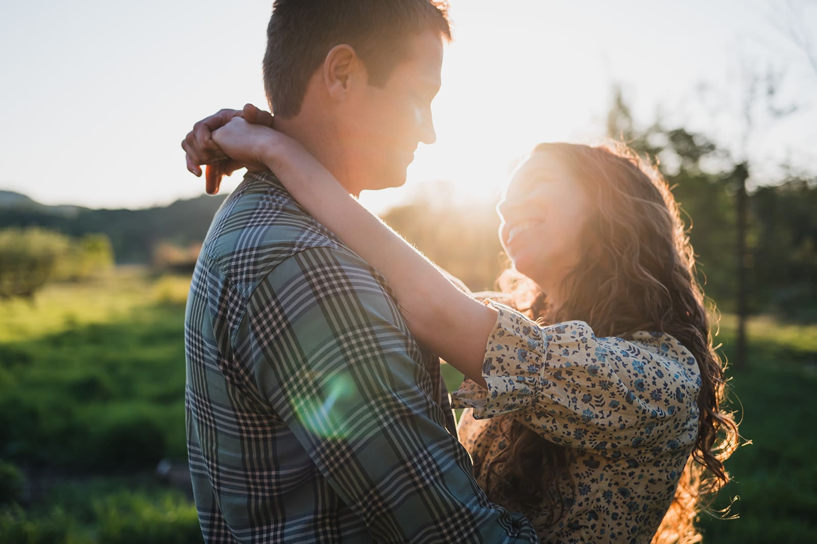 couple embracing outdoors at sunset during natural outdoor family photo session
