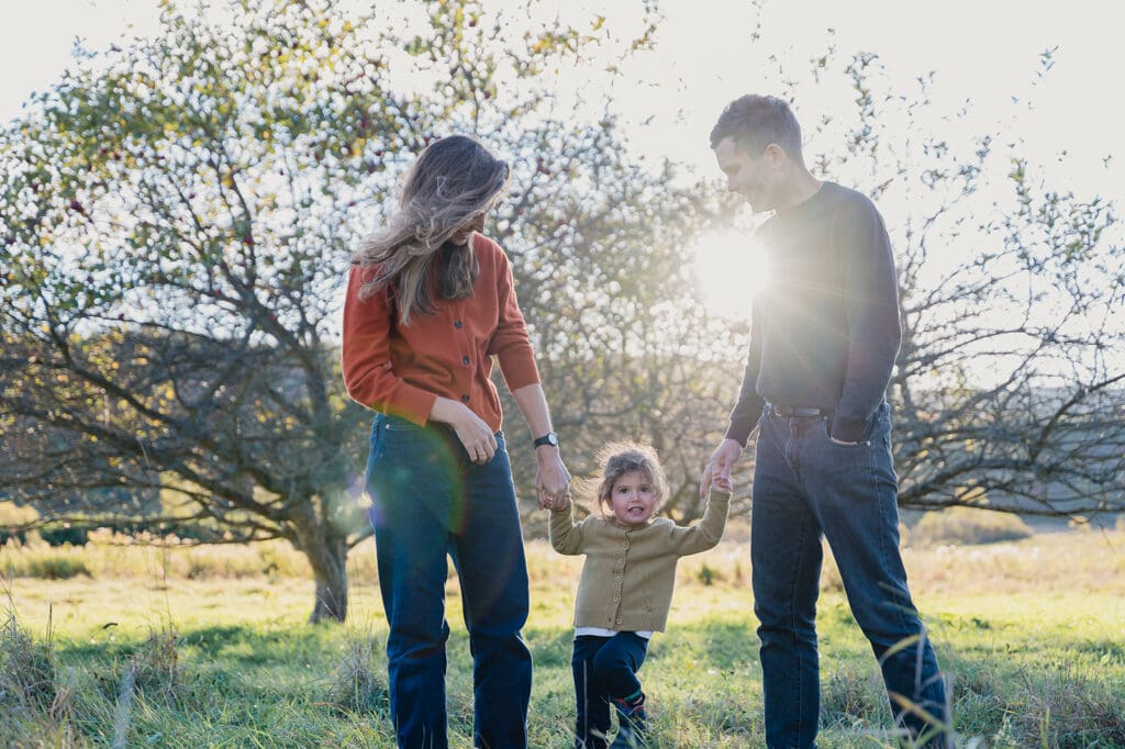 family walking together outdoors holding hands during a natural outdoor family photo session