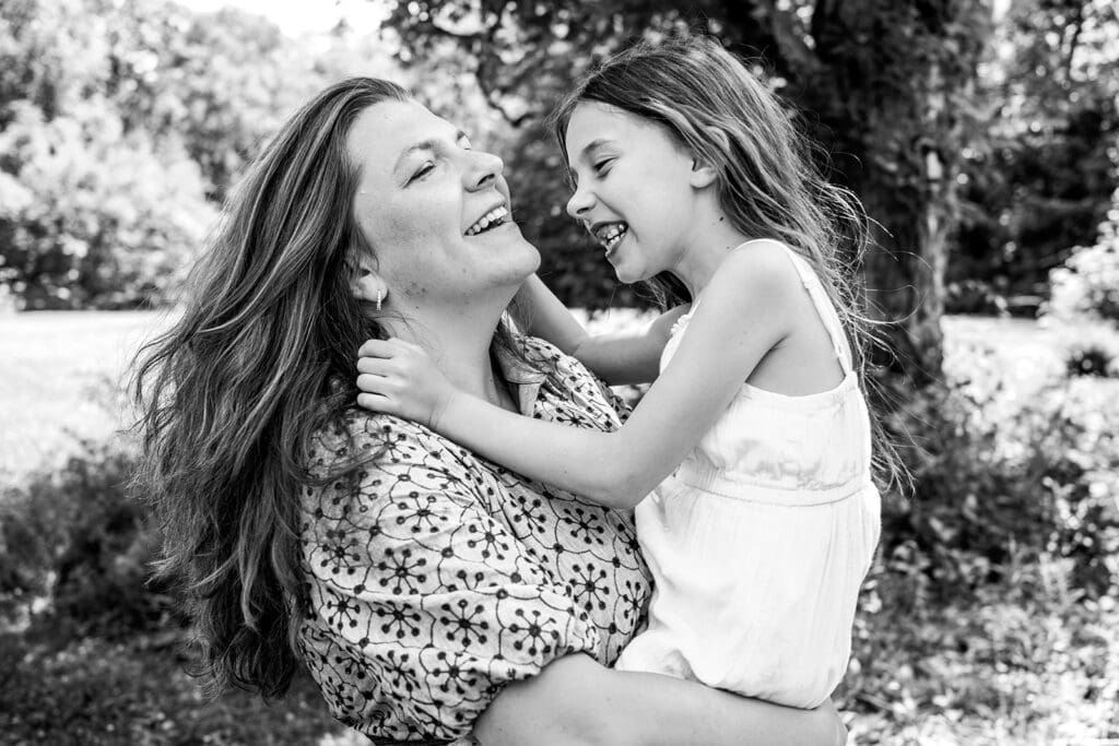 parent holding child laughing together during outdoor family photo session
