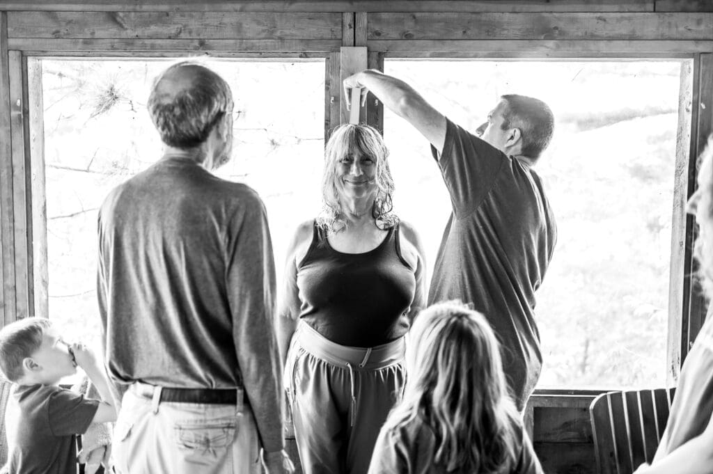 grandmother measured on height chart during Hudson Valley vacation family photography session